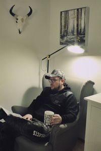 Young man sitting on sofa at home