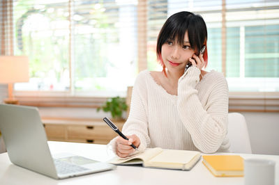 Young woman using digital tablet at office