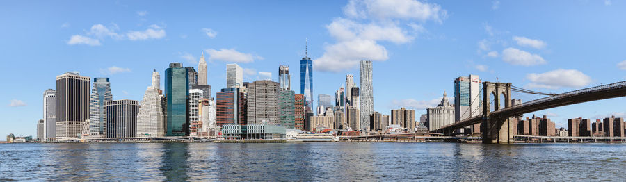 Panoramic view of city by river and buildings against sky