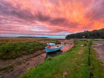 Boat on beach against sky during sunset