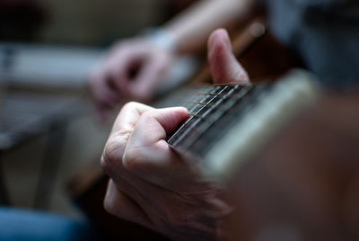 Midsection of man playing guitar