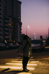 Young woman with eyes closed on road at night