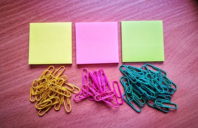 Close-up of multi colored papers and paper clips on table