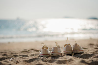 2 pairs of shoes placed on the beach with the sea in the background, sunshine in the evening
