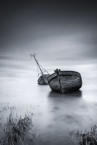 Fishing boat in sea against sky