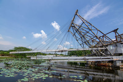 Low angle view of bridge over river against sky