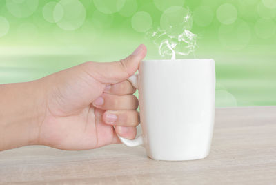 Close-up of person holding hands on table