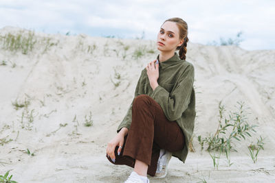 Fashion beauty portrait of young woman in green organic velvet shirt on desert background