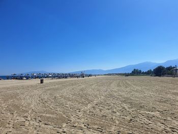 Scenic view of beach against clear blue sky