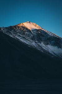 Scenic view of snowcapped mountains against clear blue sky