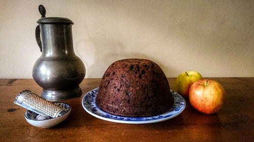 Christmas pudding and apples on table