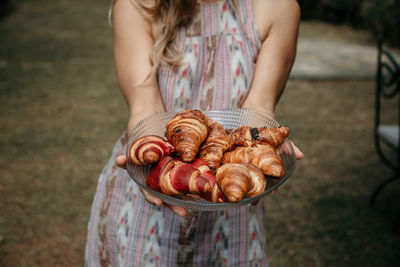 Midsection of woman holding ice cream standing outdoors