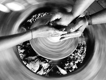 Cropped hands of people making pottery