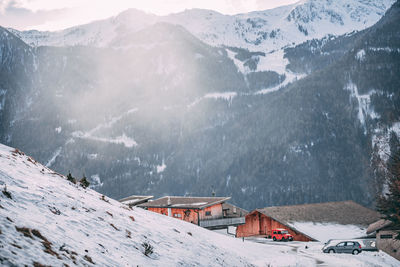 Houses against snow covered mountains