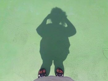 Low section of woman standing on shadow
