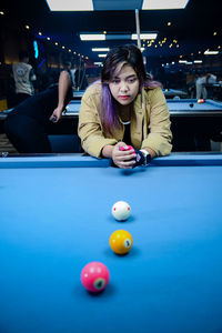 Portrait of woman playing pool