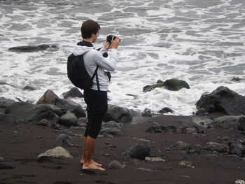 Rear view of woman photographing sea