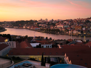 High angle view of townscape by sea against sky during sunset