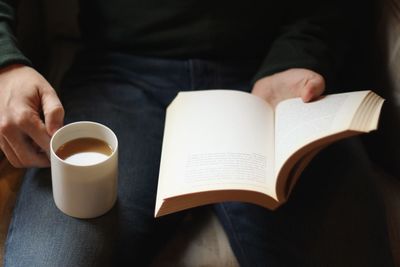 Midsection of man holding book