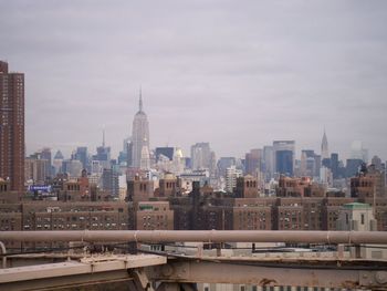 Buildings in city against cloudy sky