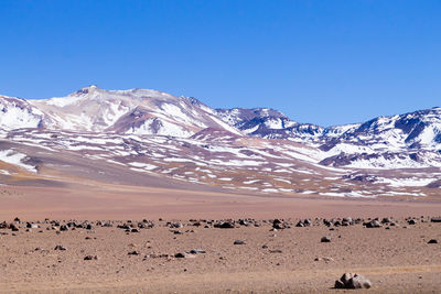 Scenic view of snowcapped mountains against clear blue sky