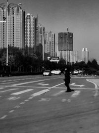 Man on road against buildings in city