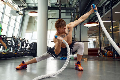 Side view of woman exercising in gym