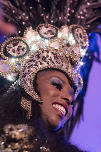 Close-up of smiling young woman wearing headwear during carnival