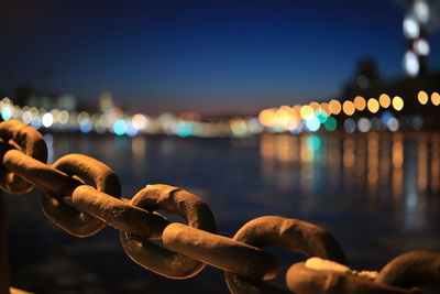 Close-up of illuminated chain against sky at night