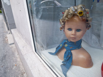 Portrait of cute girl looking through glass window