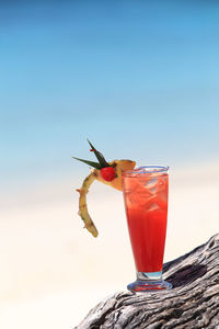 Close-up of drink on glass against blue sky