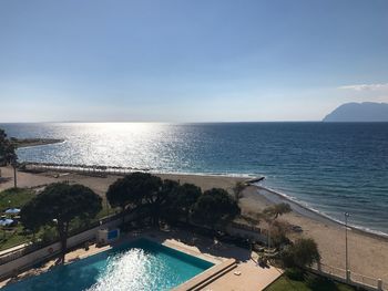 Swimming pool by sea against sky