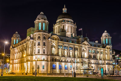 Low angle view of illuminated building against sky at night