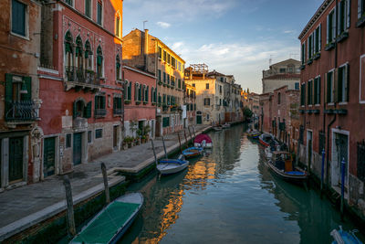 Boats moored in canal along buildings