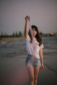 Full length of woman standing at beach against sky