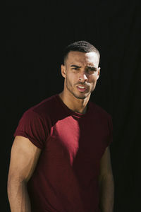 Portrait of young african american against black backdrop