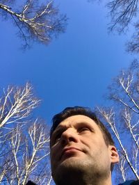 Portrait of young man looking away against sky