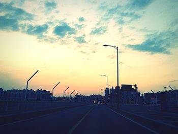 Road against cloudy sky at sunset