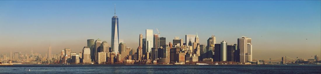 Panoramic view of cityscape by east river against sky during sunset