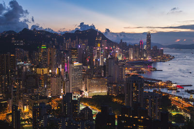 Illuminated buildings in city against sky at night