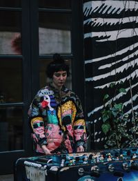 Young woman standing against window