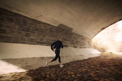 Woman jogging in old tunnel