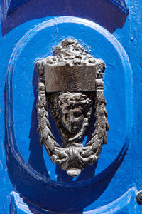 Close-up of sculpture on blue door