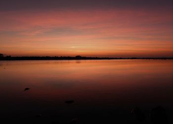 Scenic view of lake against orange sky