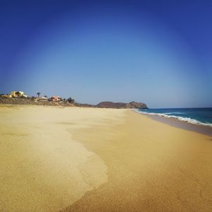 Scenic view of beach against blue sky