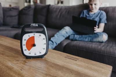 Boy spending time with laptop according to clock