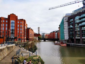 Canal amidst buildings in city against sky