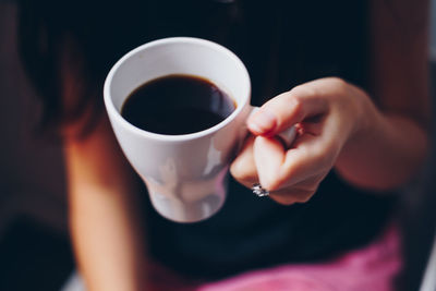 Midsection of woman holding coffee cup