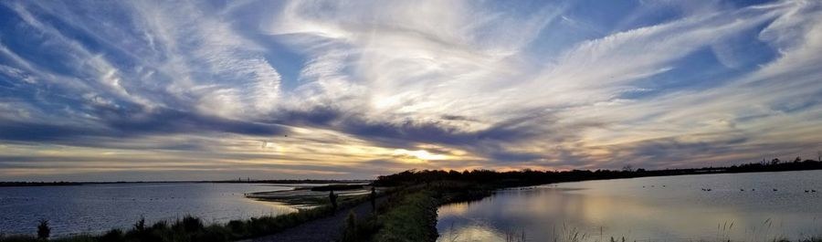 Scenic view of lake against sky at sunset