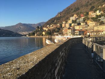 Scenic view of river by mountains against clear sky